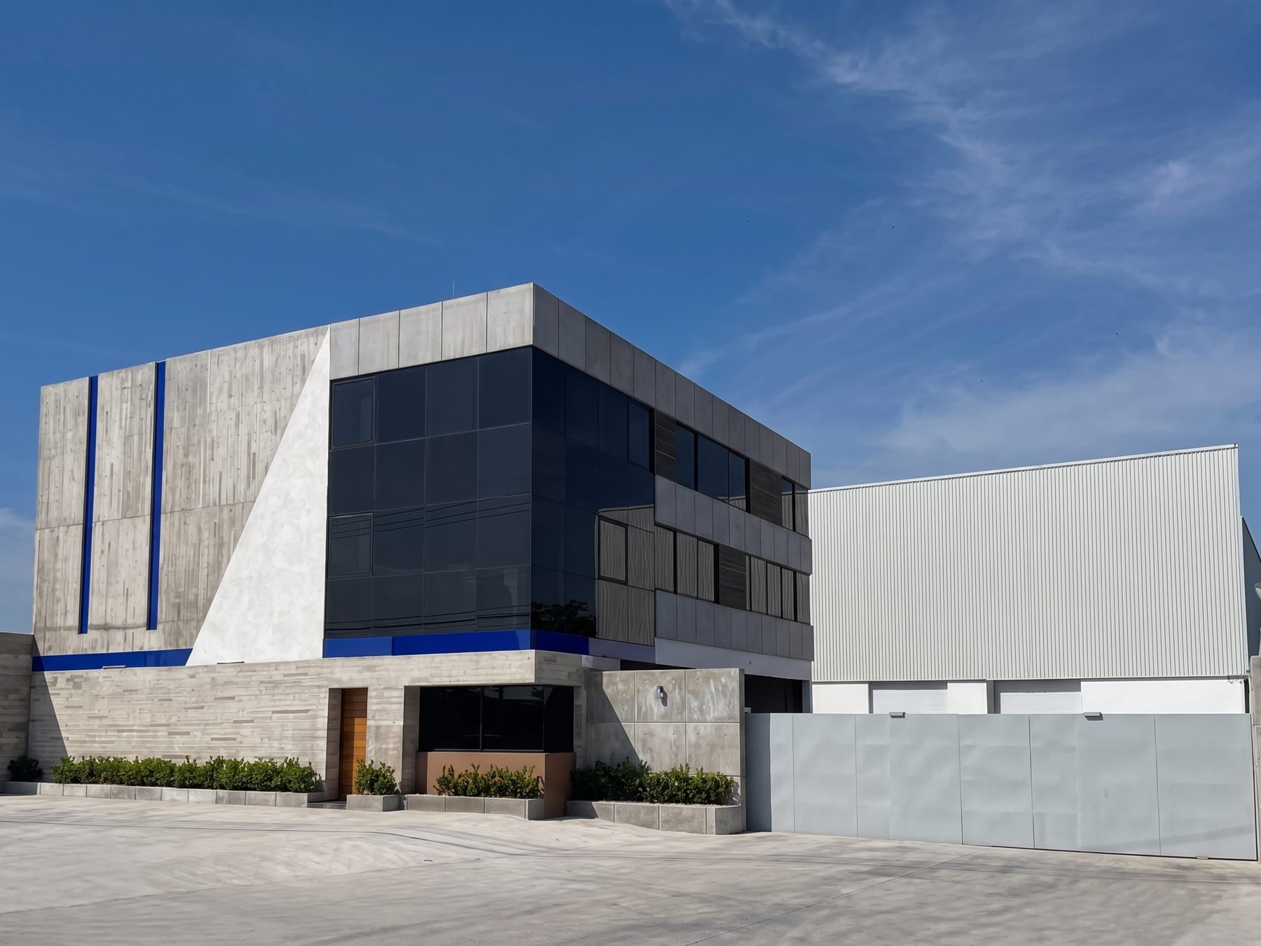 Edificio corporativo de tres niveles con fachada de concreto aparente y cristal, Veracruz